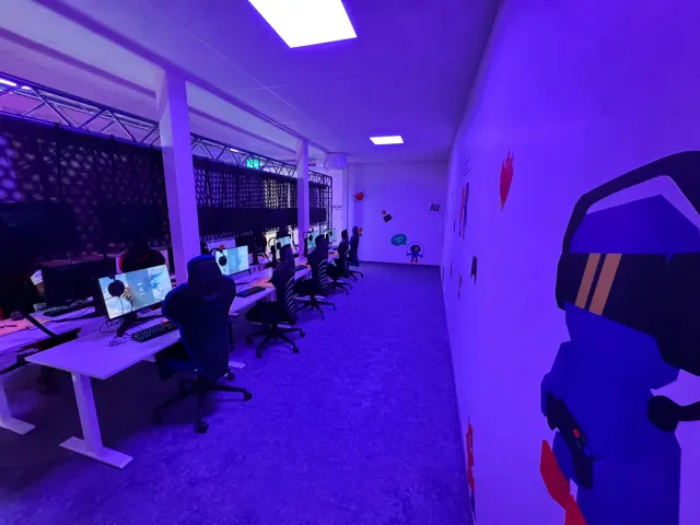 Ett spelrum med blå belysning och rader av datorer på FUZED Borås