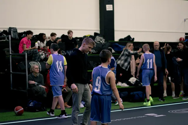 En grupp ungdomar som samlas vid basketplanen