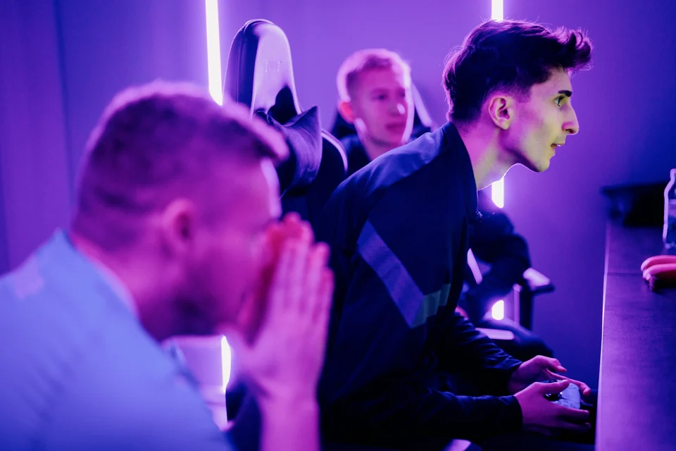 Ungdomar som spelar tillsammans i en FUZED-arena med lila belysning