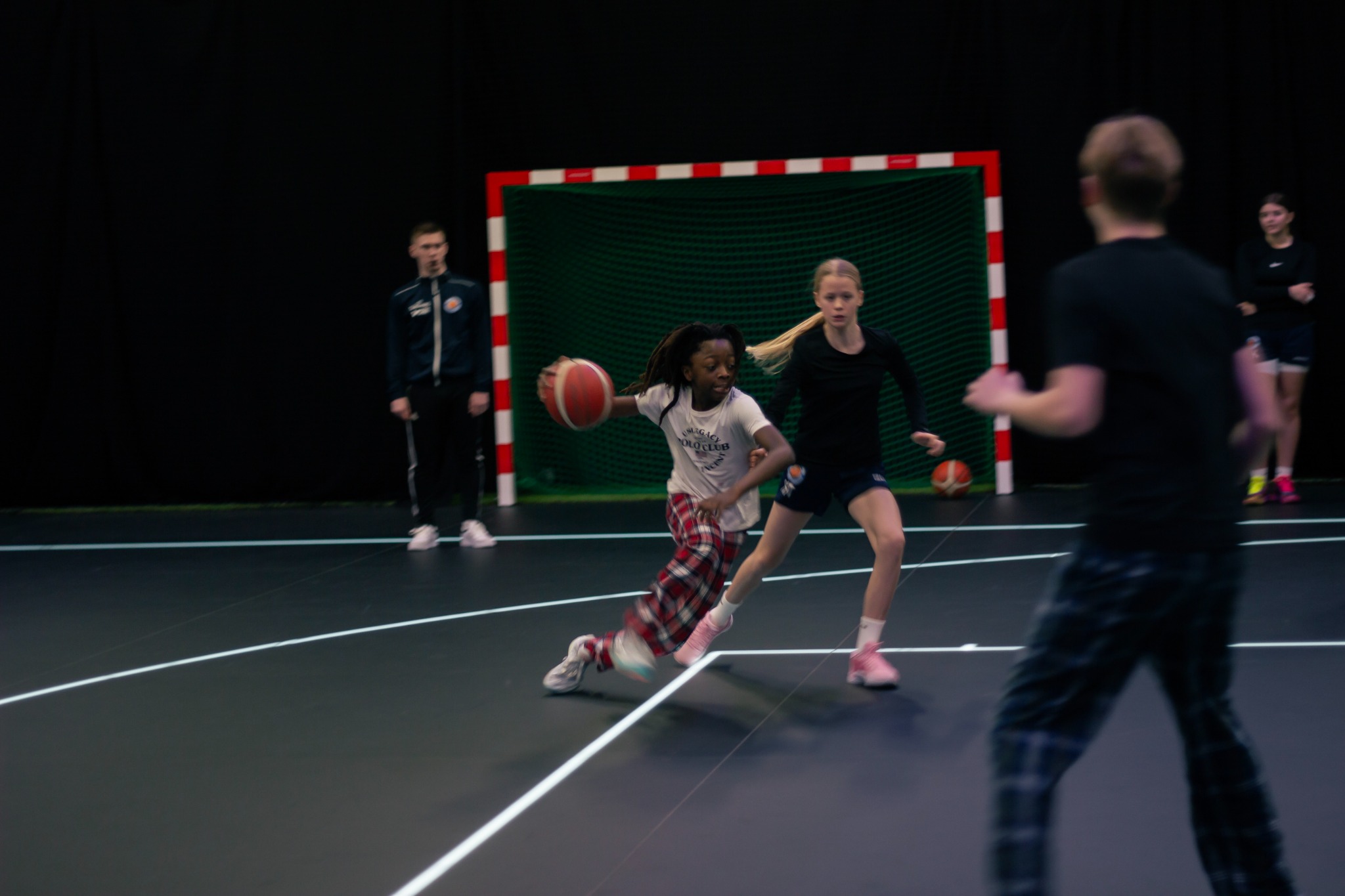 Barn som spelar basket tillsammans på en inomhusplan