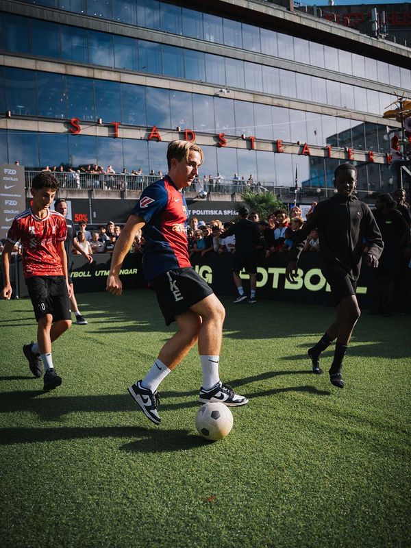 Unga fotbollsspelare som kämpar om bollen på FUZED-planen
