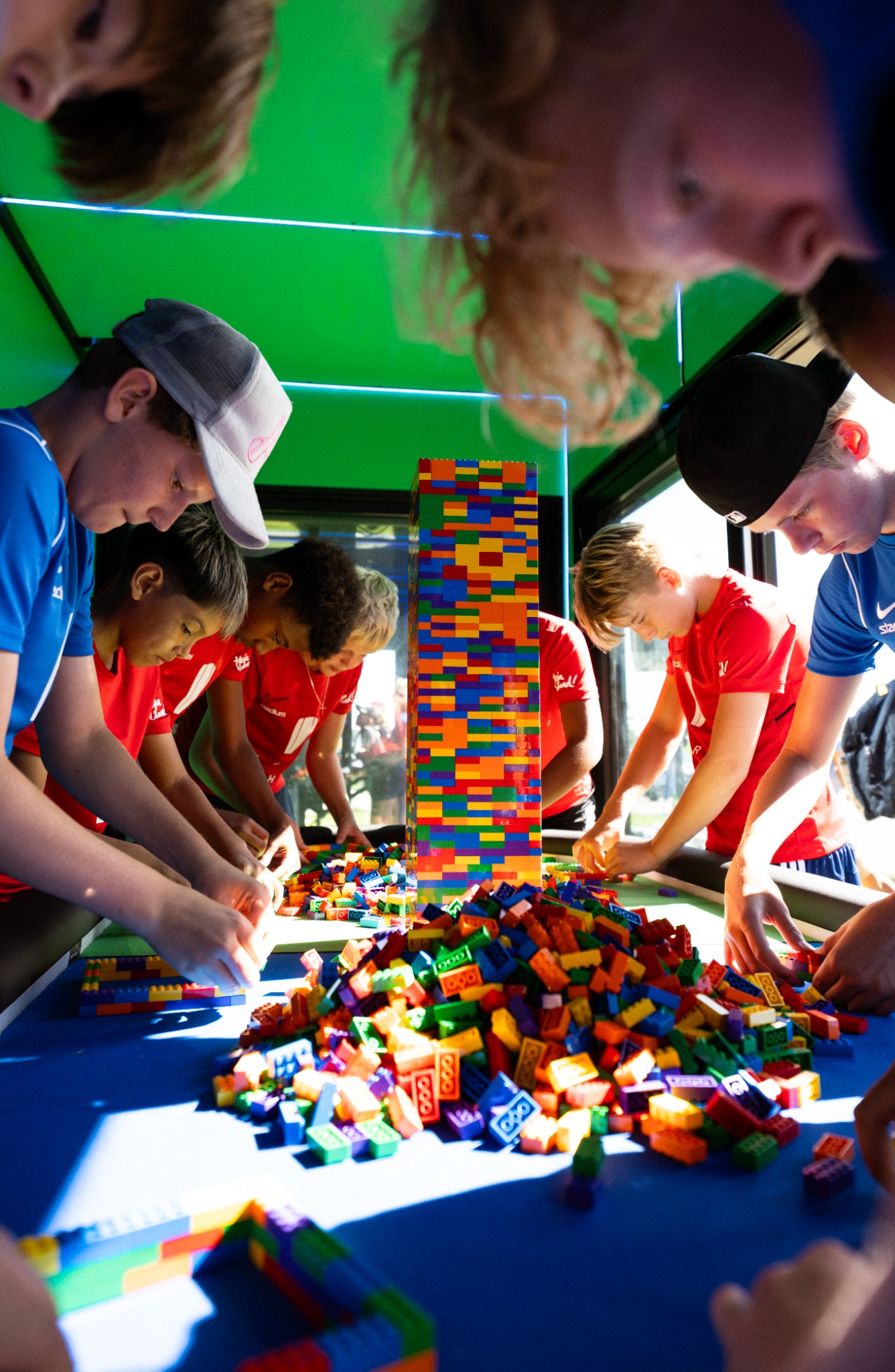 Lag som bygger med färgglada LEGO-klossar runt ett gemensamt bord