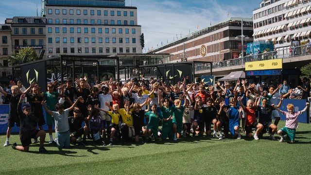 Spelare och besökare som lyfter armarna tillsammans på fotbollsplanen